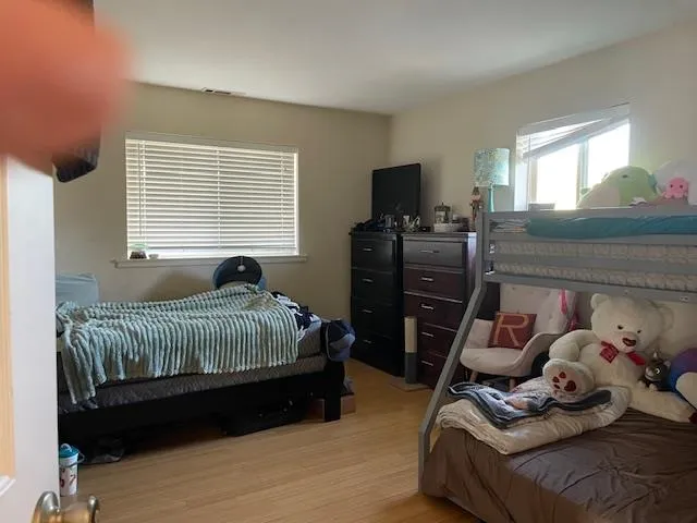 a bedroom with a bed and wooden floor