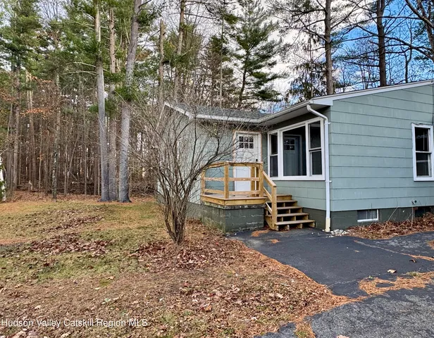 a backyard of a house with barbeque oven and trees
