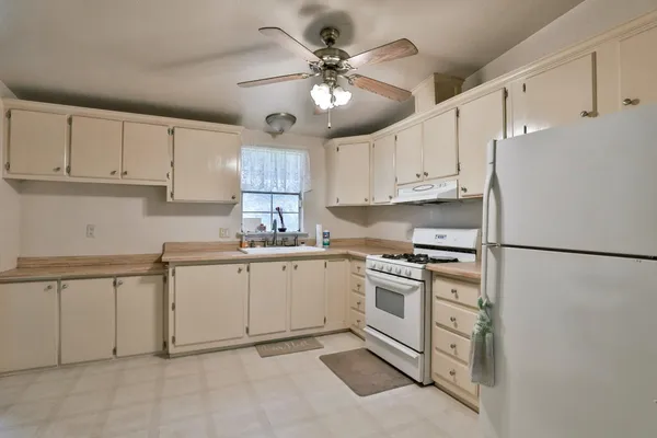 a kitchen with cabinets appliances and a window
