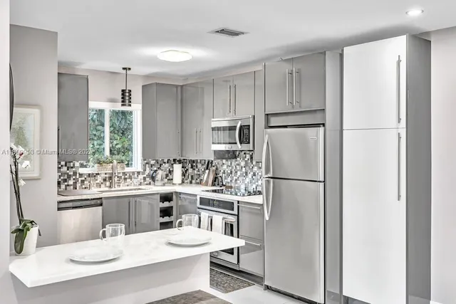 a view of a kitchen with stainless steel appliances a refrigerator and a sink
