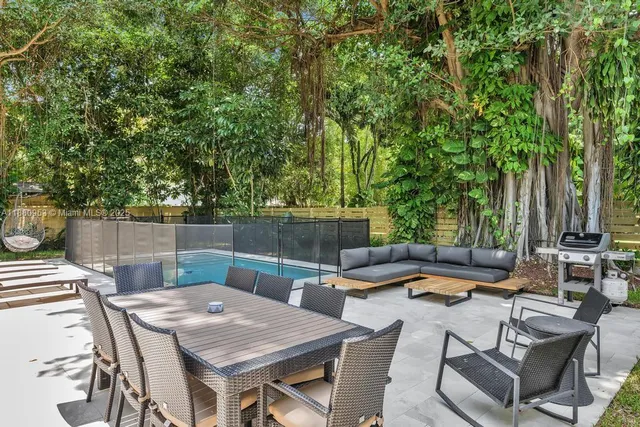 a kitchen with stainless steel appliances a refrigerator a sink a stove a dining table and chairs