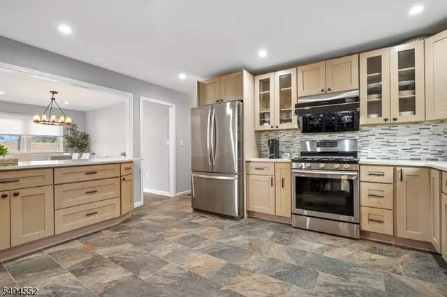a kitchen with granite countertop a refrigerator stove and oven