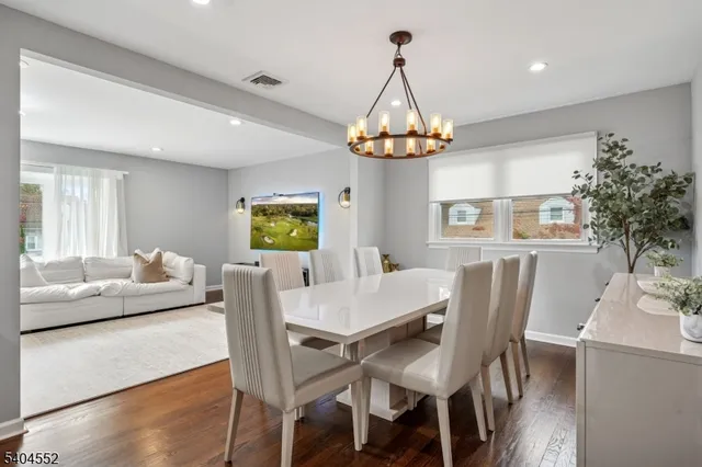 a view of a dining room with furniture a chandelier and wooden floor