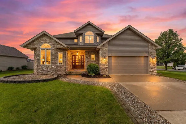 a front view of a house with a yard and garage