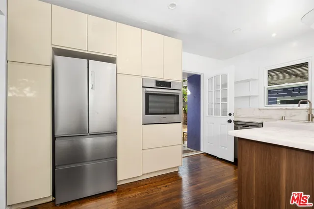 a kitchen with stainless steel appliances a refrigerator and a stove top oven