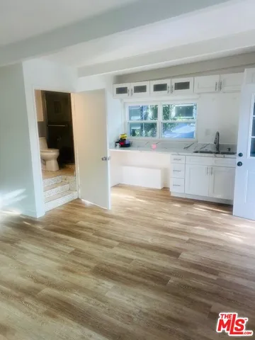 a view of a kitchen with kitchen island a counter top space and wooden floor