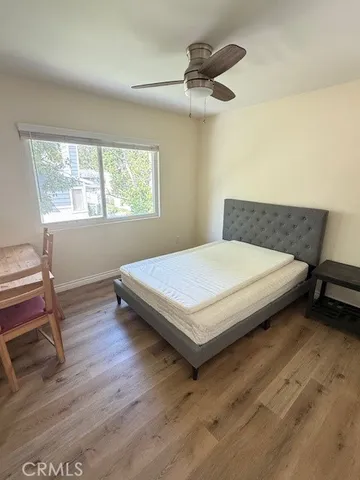 a bedroom with a bed a window and a dresser