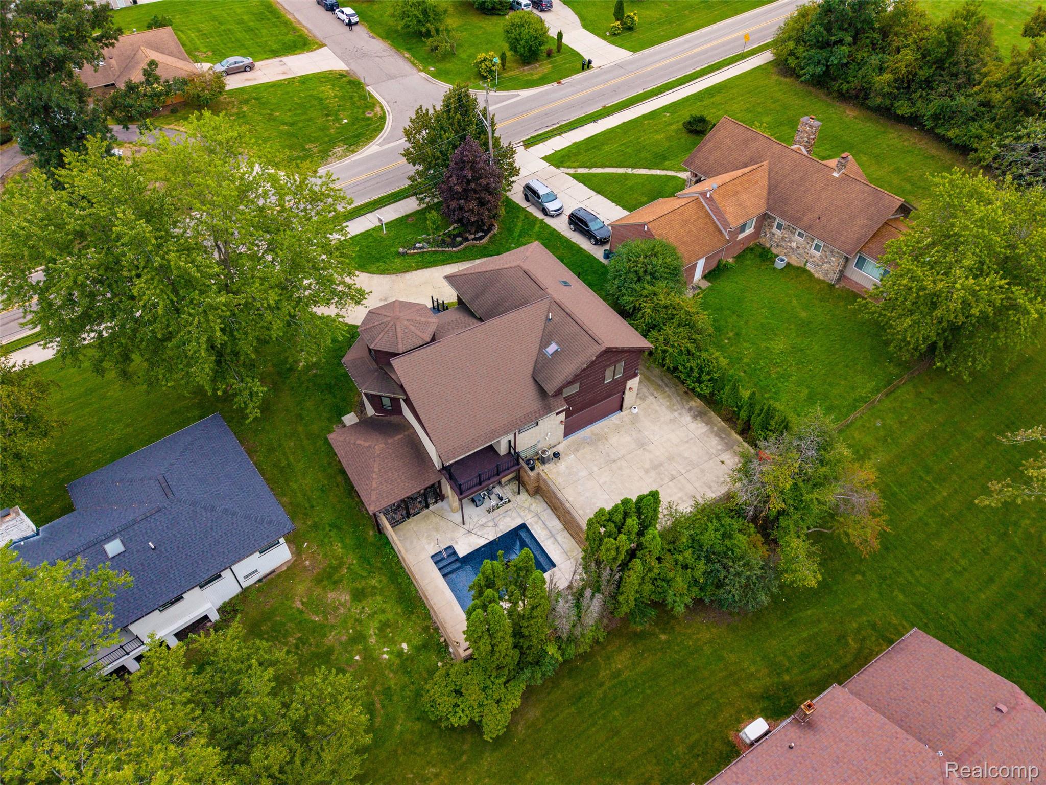 27507 Bell Road Southfield, MI 48034 - Photo 71 of 81 Expansive property featuring an in-ground swimming pool, concrete patio, mature trees, and a detached garage with a concrete driveway