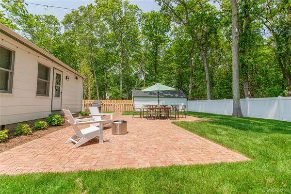 a view of a house with backyard and sitting area