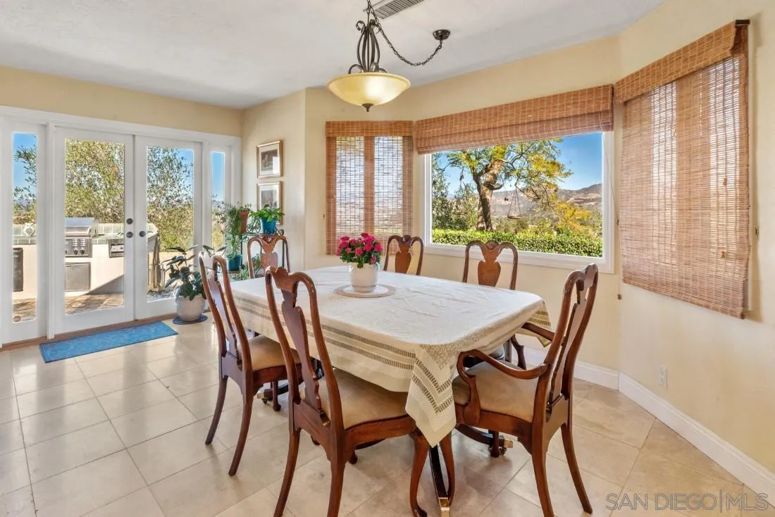 16033 Stoney Acres Road Poway, CA 92064 - Photo 20 of 60 a view of a dining room with furniture large windows and wooden floor