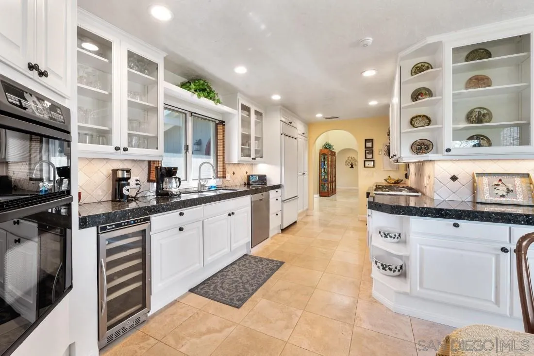 16033 Stoney Acres Road Poway, CA 92064 - Photo 21 of 60 a large kitchen with stainless steel appliances granite countertop a stove and cabinets