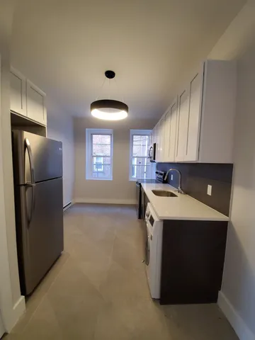 a kitchen with a sink a refrigerator and window
