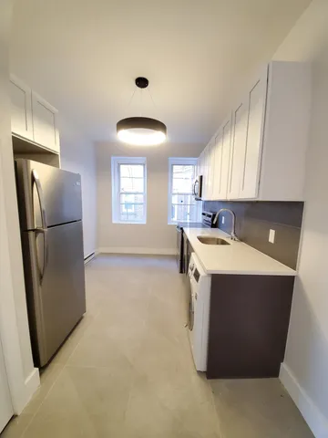 a kitchen with a refrigerator sink and cabinets