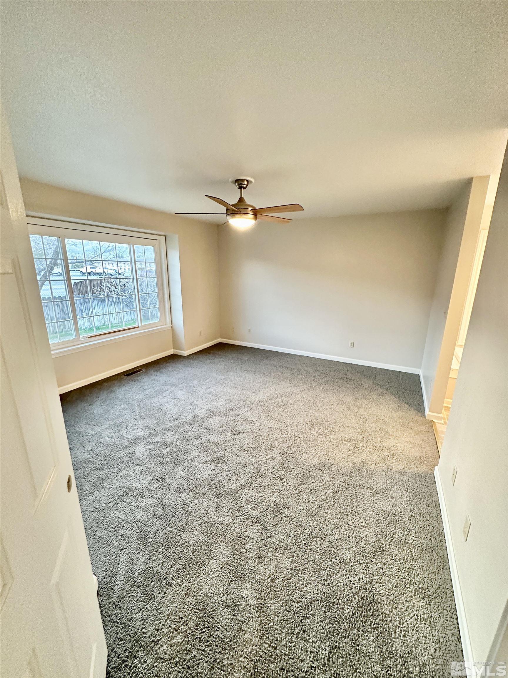 254 Windtree Circle Carson City, NV 89701 - Photo 11 of 23 an empty room with a ceiling fan and window