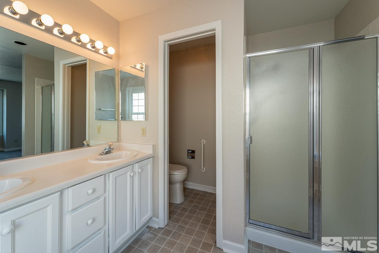 254 Windtree Circle Carson City, NV 89701 - Photo 13 of 23 a spacious bathroom with a granite countertop sink a toilet and a mirror
