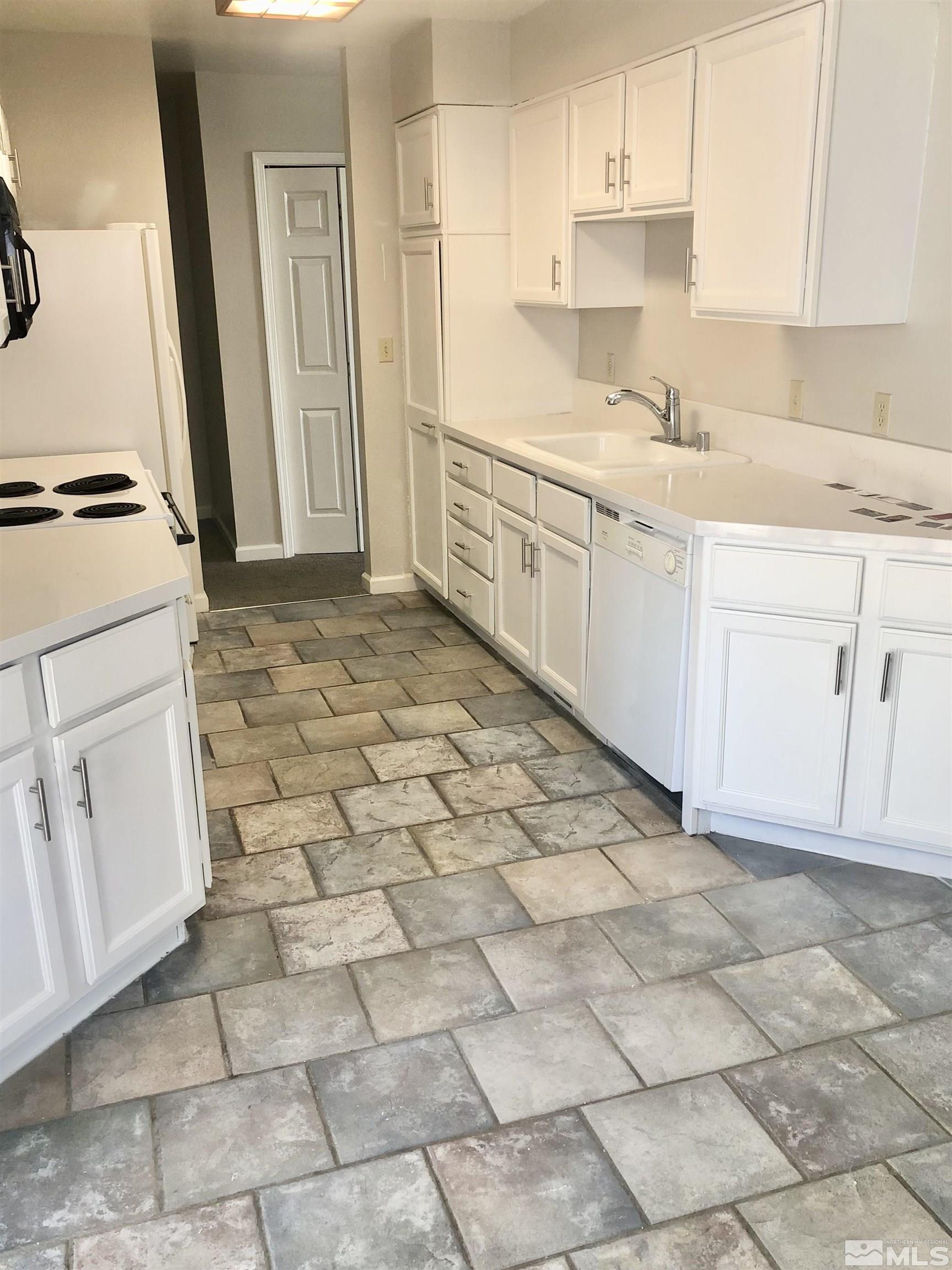 254 Windtree Circle Carson City, NV 89701 - Photo 8 of 23 a kitchen with a stove a sink a refrigerator a window and white cabinets