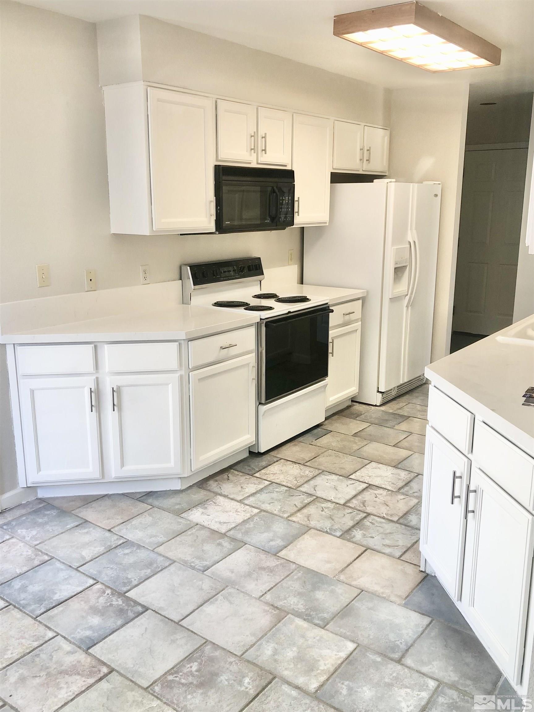 254 Windtree Circle Carson City, NV 89701 - Photo 9 of 23 a kitchen with white cabinets a sink and white appliances