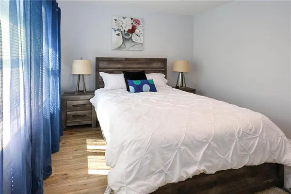 a bedroom with a bed and painting on the wall