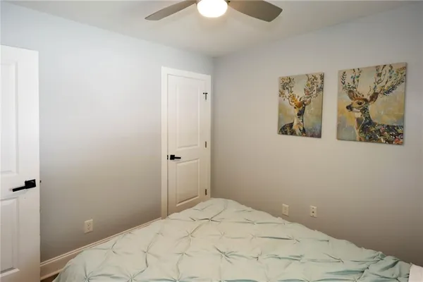 a bedroom with a bed and a painting on the wall
