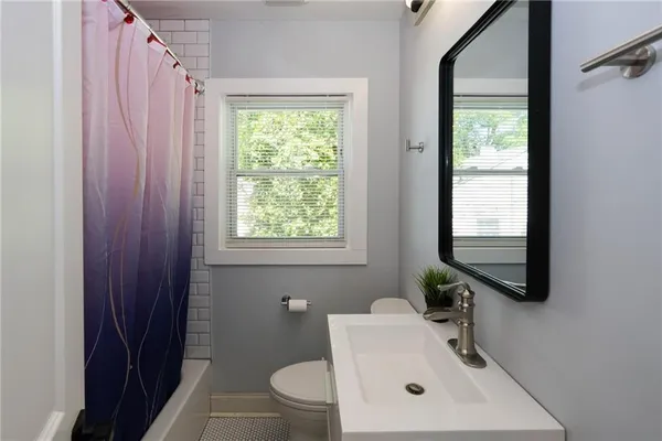 a bathroom with a toilet a sink and a window