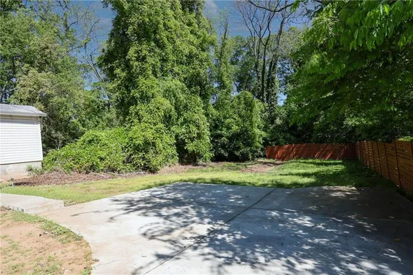 a backyard of a house with plants and wooden fence