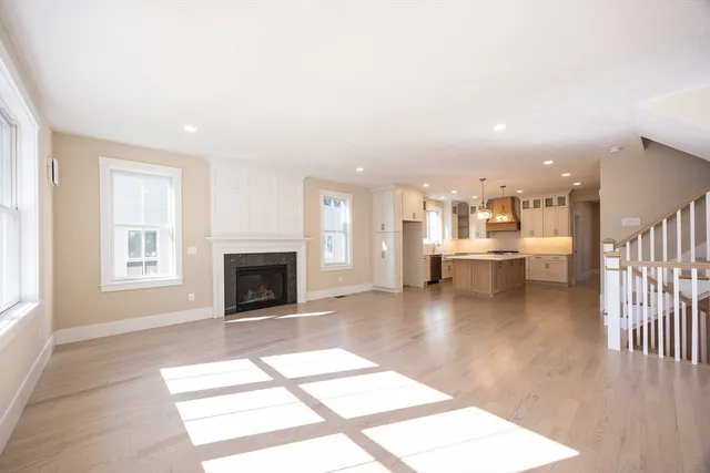 a living room with furniture a fireplace and a kitchen view