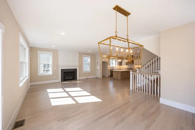 an empty room with windows and fireplace