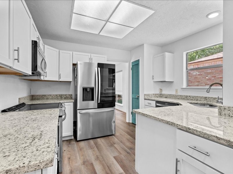 6631 Ambler Drive Spring, TX 77379 - Photo 4 of 37 a kitchen with granite countertop a sink stove and refrigerator