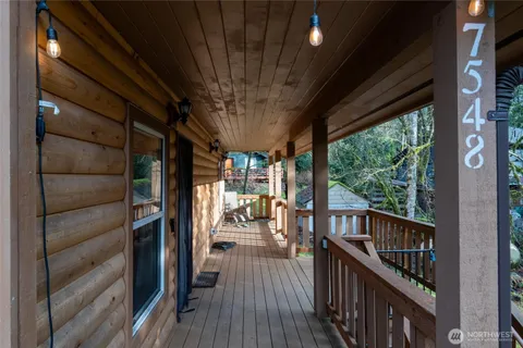 a view of a balcony with chairs and wooden floor