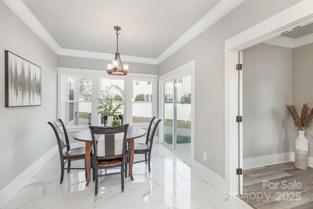a dining room with furniture a chandelier and window