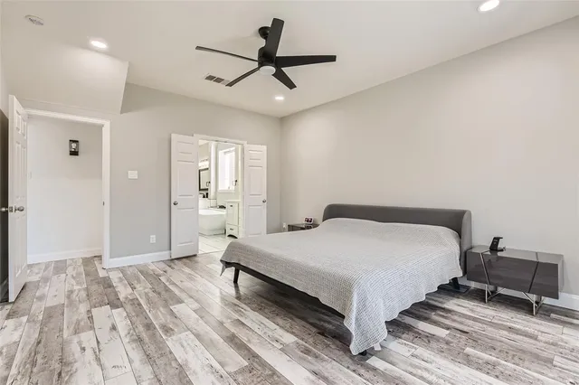 a spacious bedroom with a bed and a chandelier