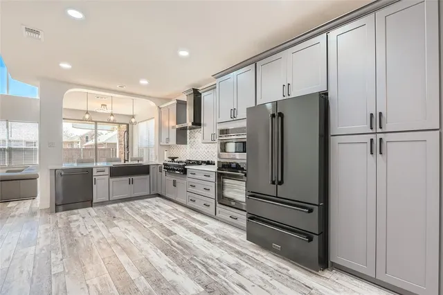 a kitchen with stainless steel appliances a refrigerator and wooden cabinets