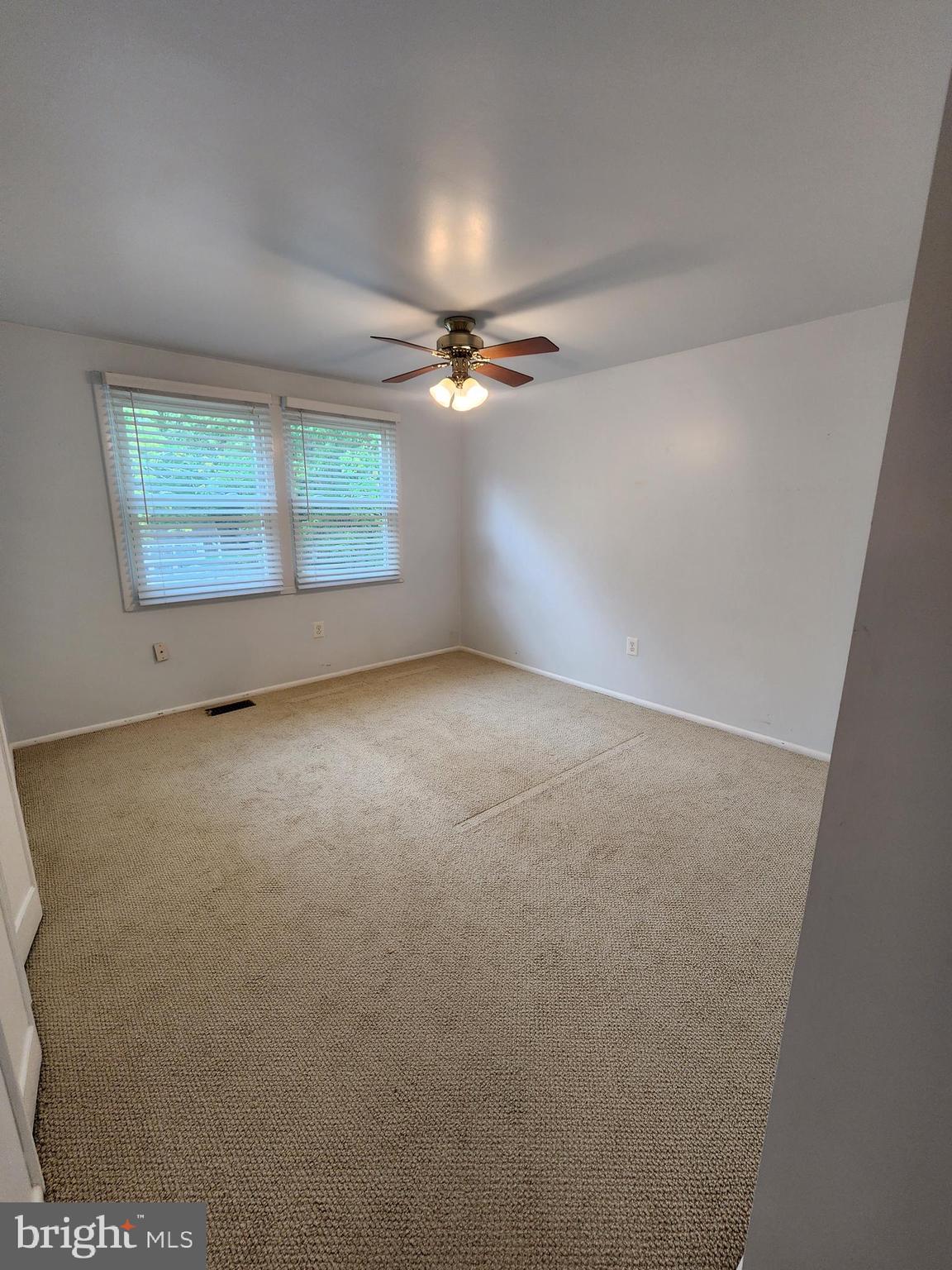 13171 Morning Spring Lane Fairfax, VA 22033 - Photo 21 of 34 an empty room with a chandelier fan and windows