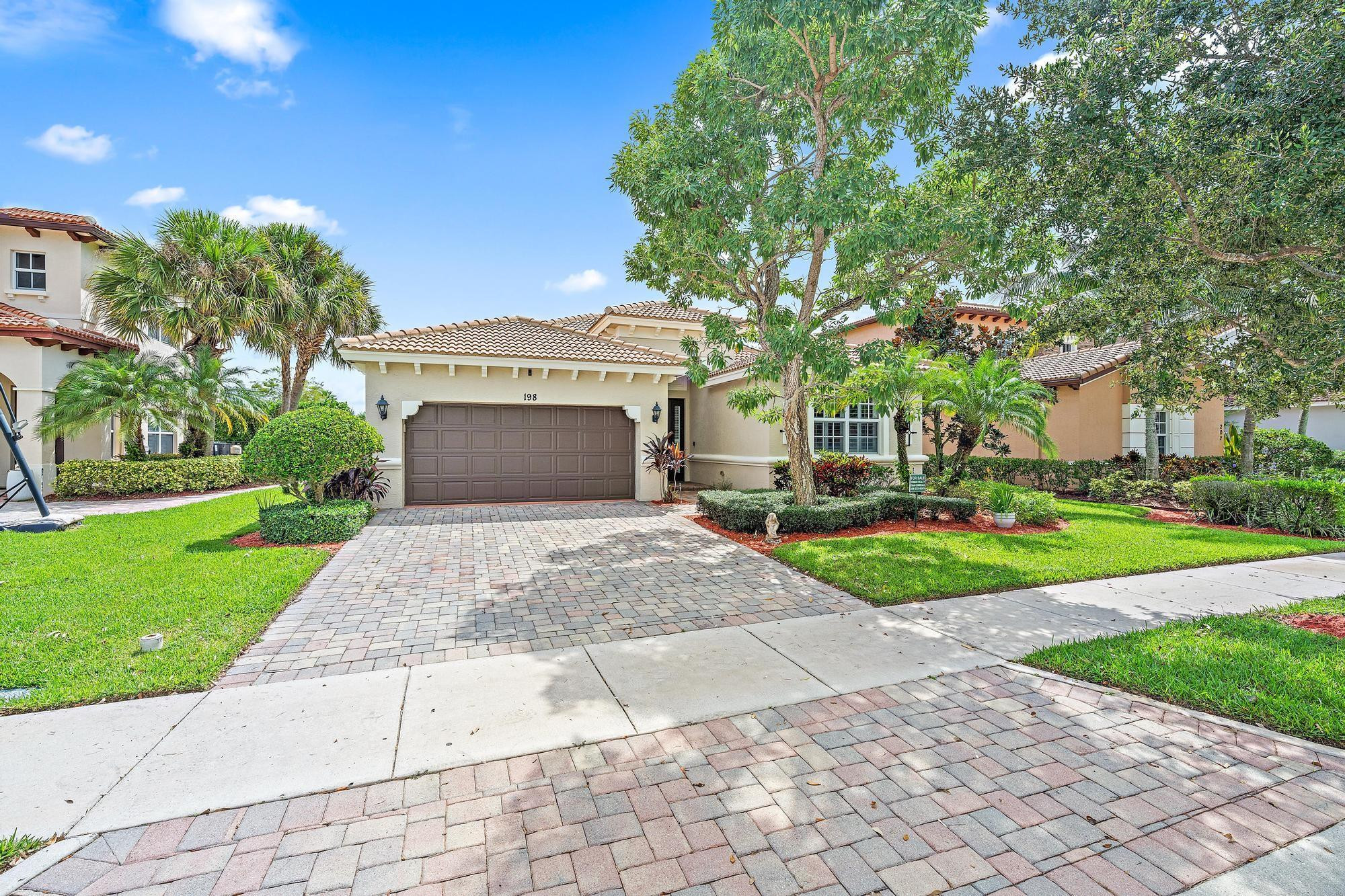198 Umbrella Place Jupiter, FL 33458 - Photo 33 of 39 a front view of a house with a yard and potted plants