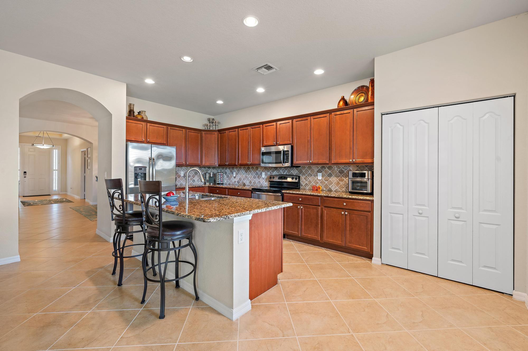 198 Umbrella Place Jupiter, FL 33458 - Photo 8 of 39 a kitchen with stainless steel appliances granite countertop a refrigerator and a stove top oven