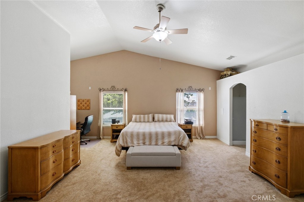 11025 El Esteban Road Phelan, CA 92371 - Photo 32 of 54 a spacious bedroom with a bed and a chandelier
