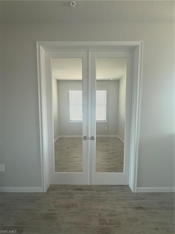 4551 Arboretum Circle, Unit 203 Naples, FL 34112 - Photo 26 of 41 an empty room with wooden floor and mirror