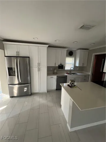 a kitchen with a sink a refrigerator and cabinets