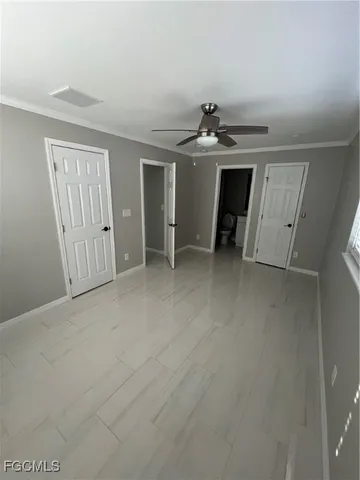 an empty room with windows and cabinet