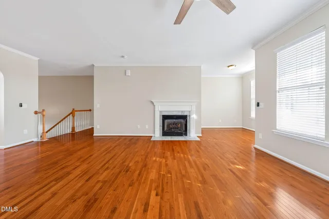 a view of empty room with wooden floor and fireplace