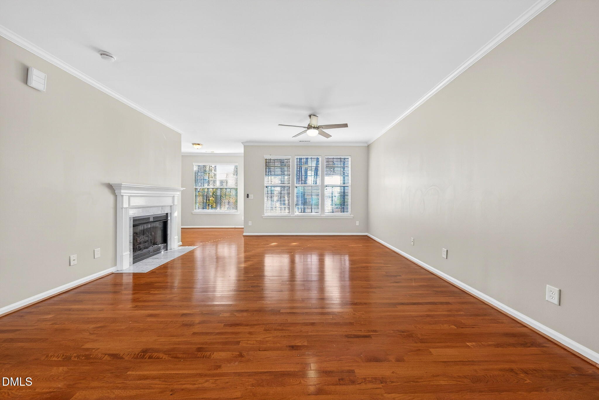 4523 Pale Moss Drive Raleigh, NC 27606 - Photo 7 of 42 an empty room with wooden floor fireplace and windows