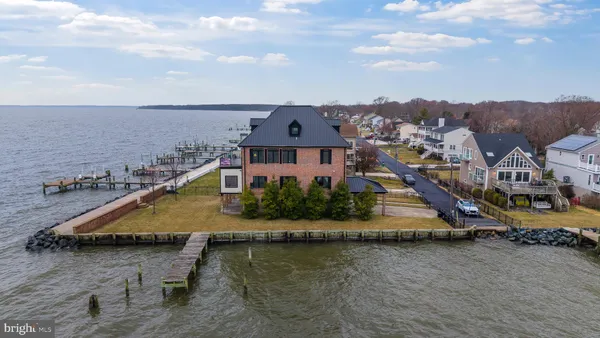 an aerial view of a house with a garden and lake view
