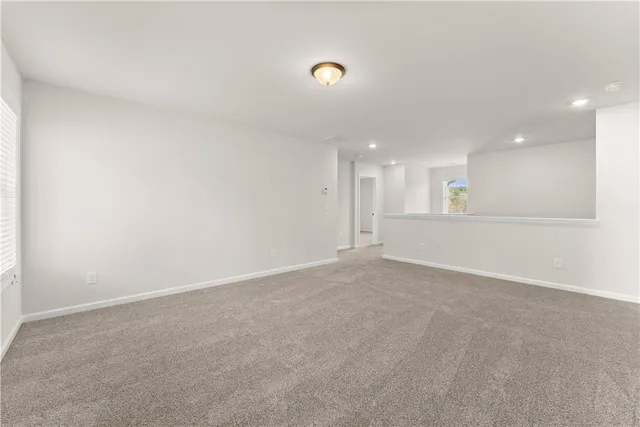 a view of an empty room with a kitchen
