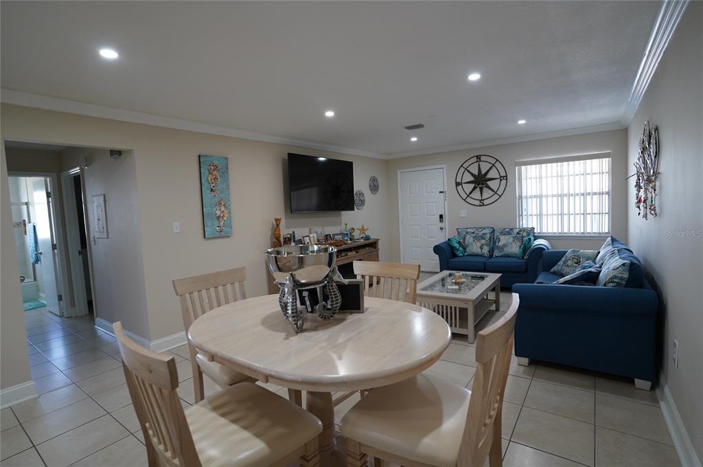 1531 Placida Road, Unit 204 Englewood, FL 34223 - Photo 7 of 52 a living room with furniture a large window and a dining table with wooden floor