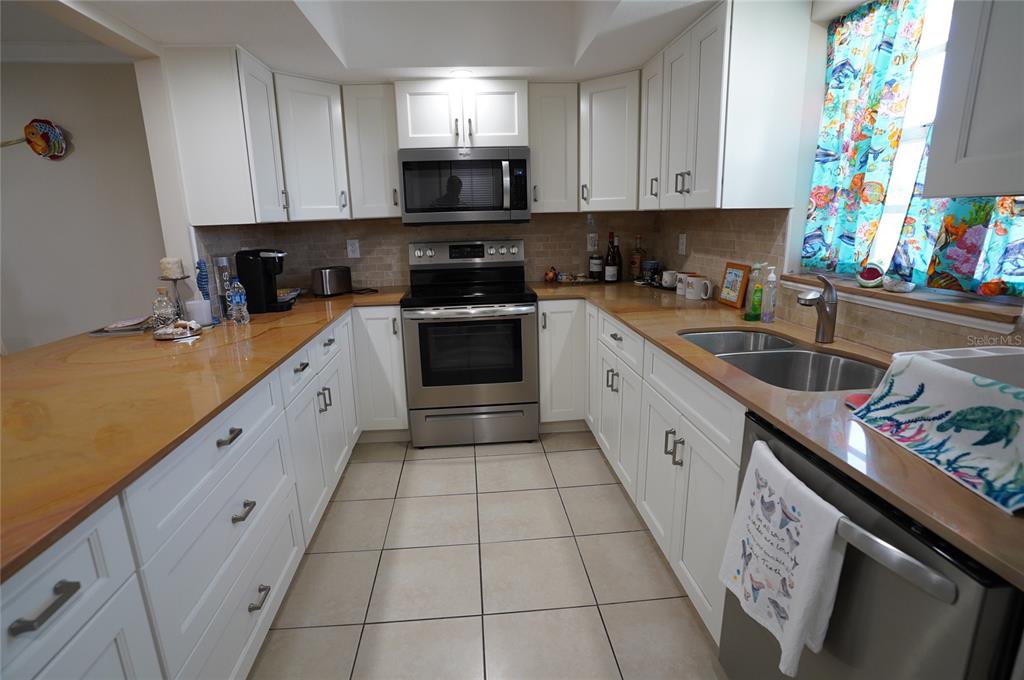 1531 Placida Road, Unit 204 Englewood, FL 34223 - Photo 10 of 52 a large kitchen with stainless steel appliances granite countertop a sink and cabinets
