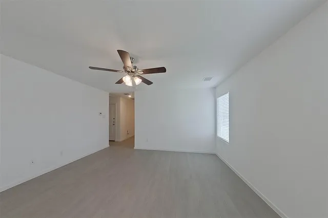 a view of empty room with ceiling fan