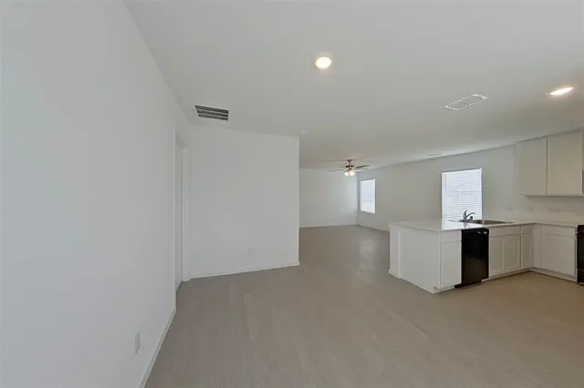 a view of a kitchen with a sink and dishwasher stove top oven with wooden floor