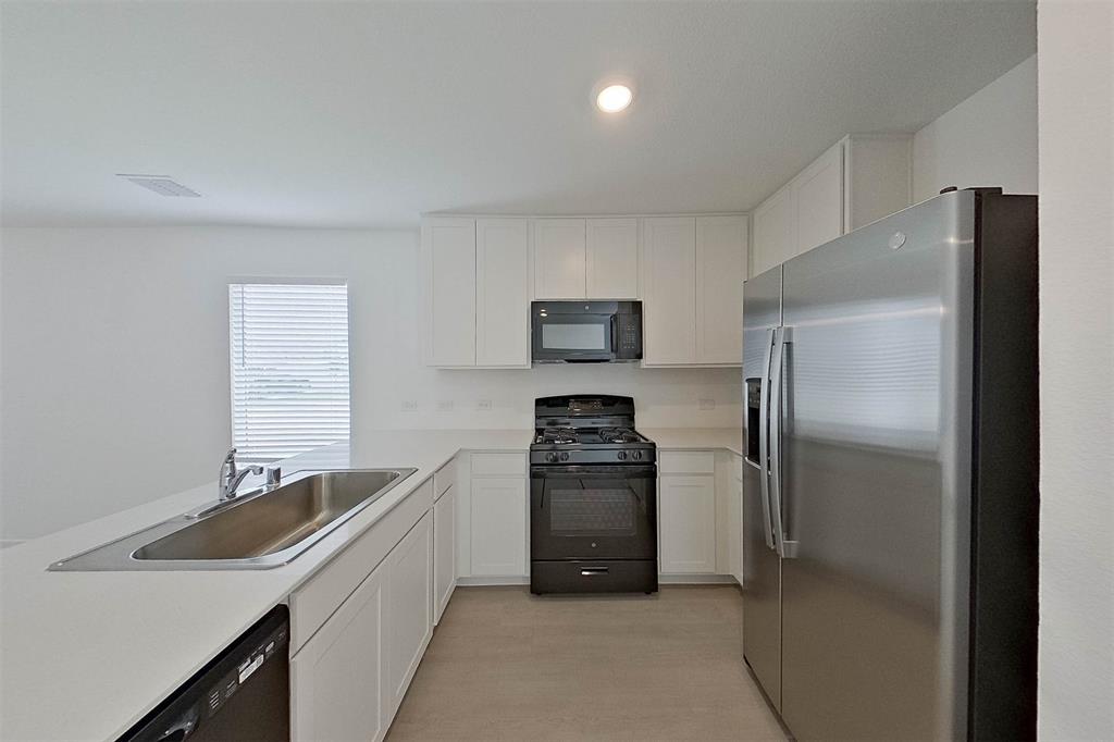 1601 Parlier Street McKinney, TX 75071 - Photo 15 of 29 a kitchen with stainless steel appliances granite countertop a refrigerator and a sink