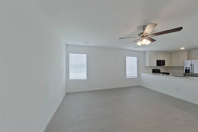 a view of a livingroom with a ceiling fan and window