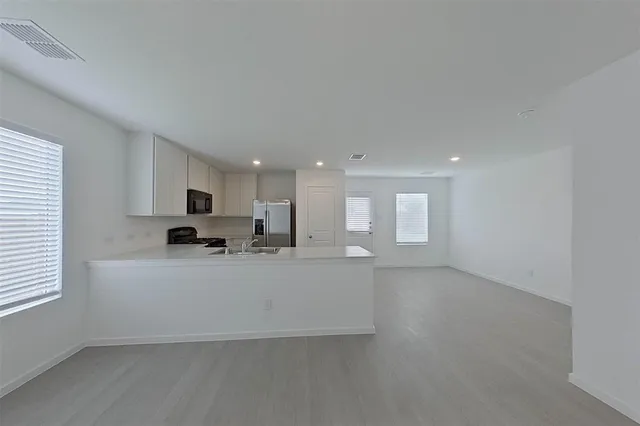 a large white kitchen with a large window